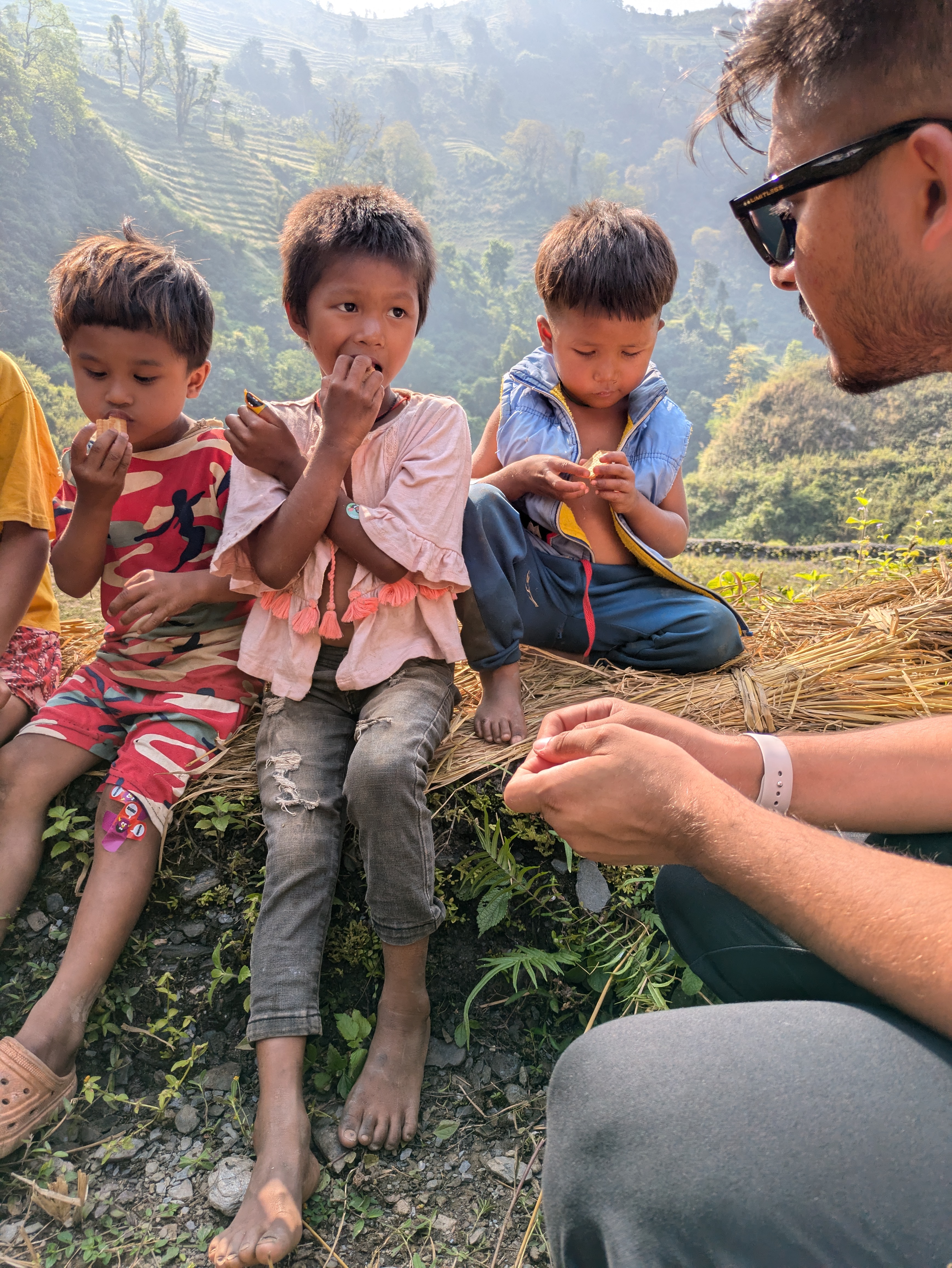 Three Nepali brothers sitting talking to volunteer